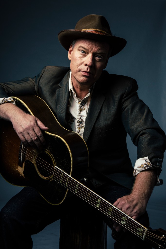 Shawn Mullins seated with his acoustic guitar